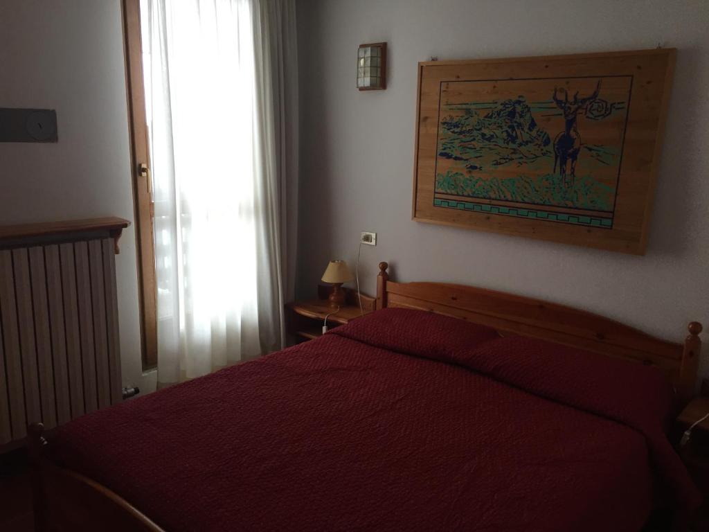ブレウイル・チェルヴィナイアにあるResidence Cervinia Dueのベッドルーム1室(赤いベッド1台、窓付)
