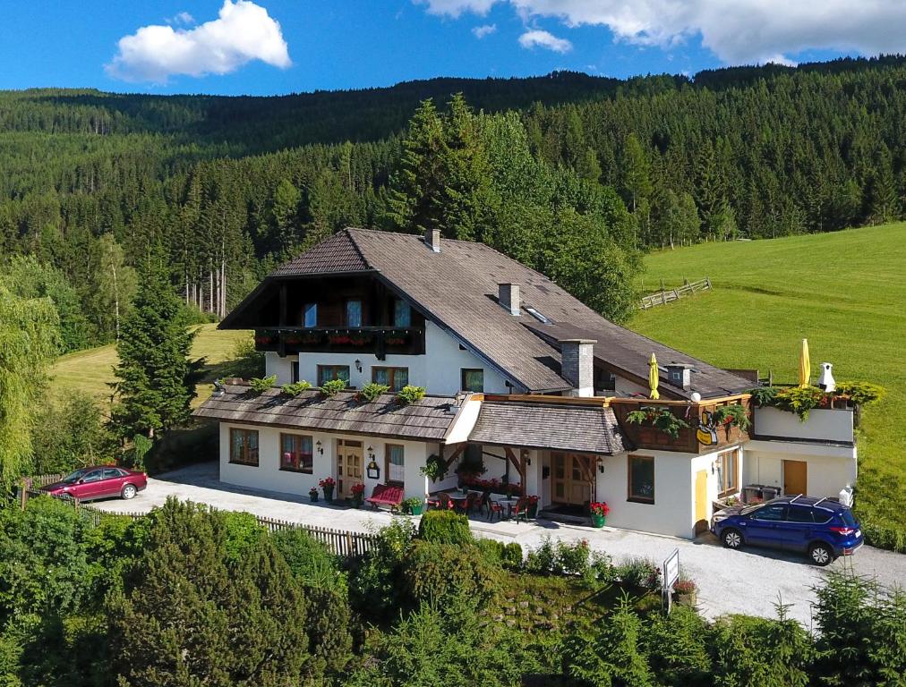 a house with a car parked in front of it at Hotel Pension Schwaiger in Sankt Margarethen im Lungau