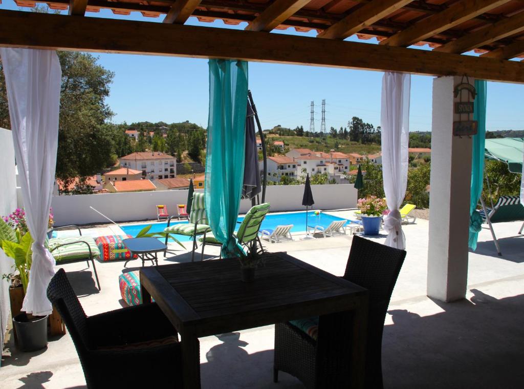 un patio con mesa, sillas y piscina en Casa do Loureiro Branco, en Santarém