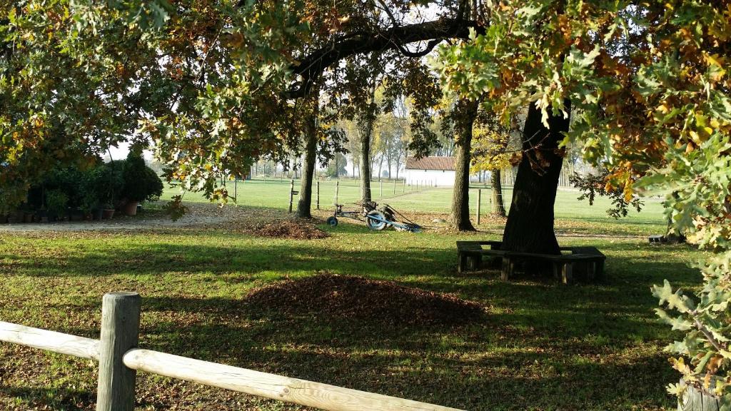 een park met een hek en een boom en een bank bij Scuderia 100 pertiche in Villanterio