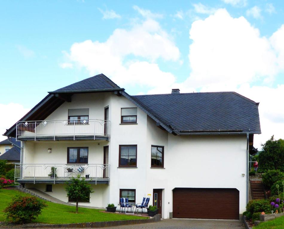 una casa blanca con techo negro y garaje en Kleeblatt, en Morbach