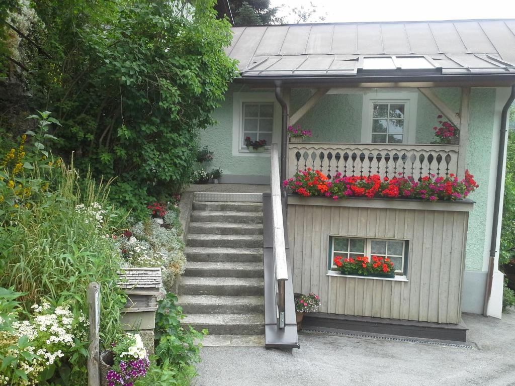 ein Haus mit einer Treppe und Blumenkästen darauf in der Unterkunft Ferienhaus Forsthof in Taxenbach