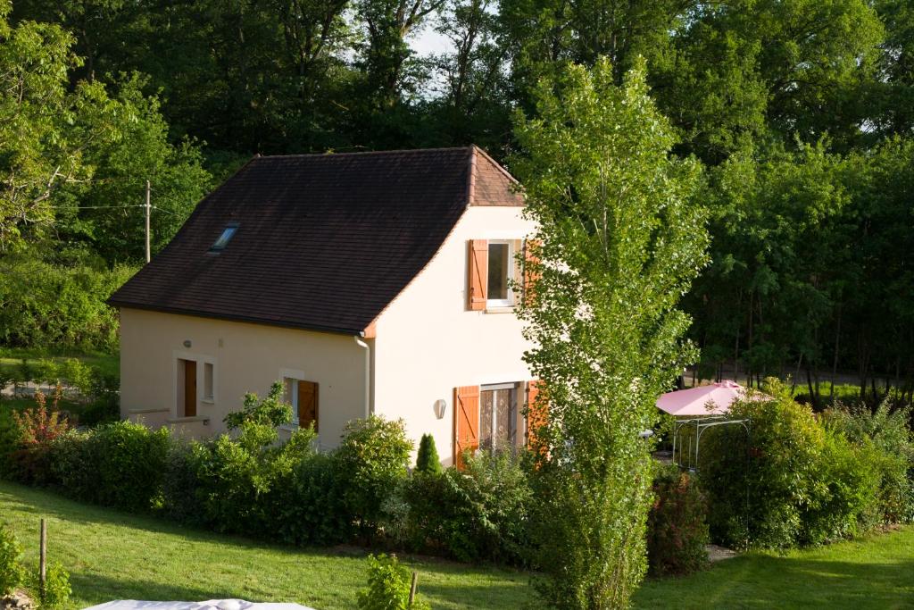 a small white house with a black roof at Gîte le Noyer - l'Ancien Vignoble in Saint-Julien-de-Lampon