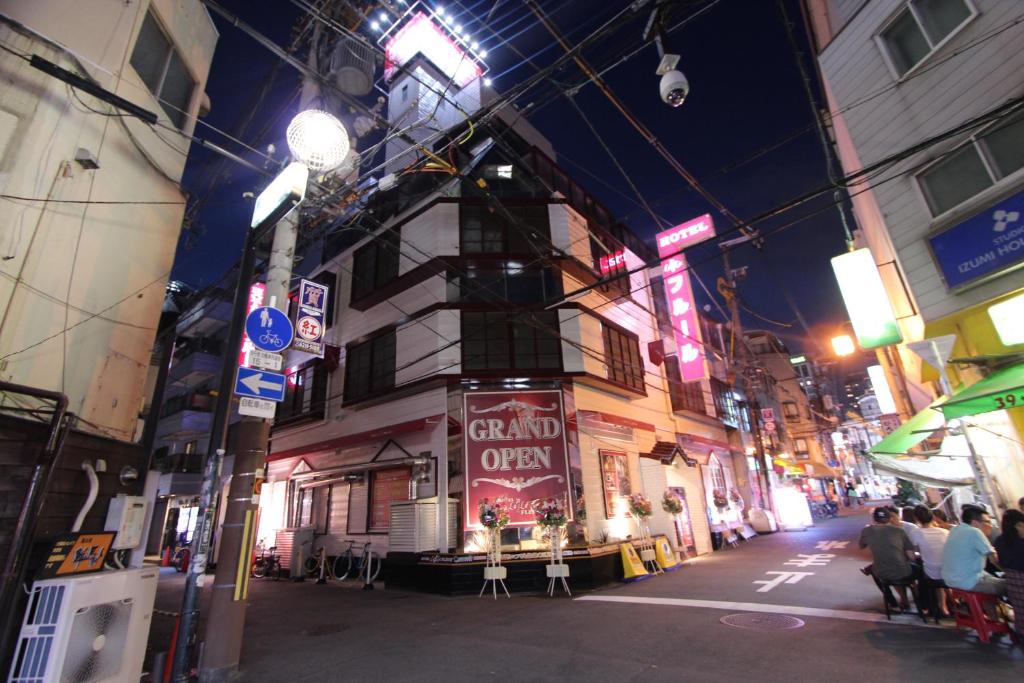 a city street at night with people sitting on chairs at Lala Fleur (Adult Only) in Osaka