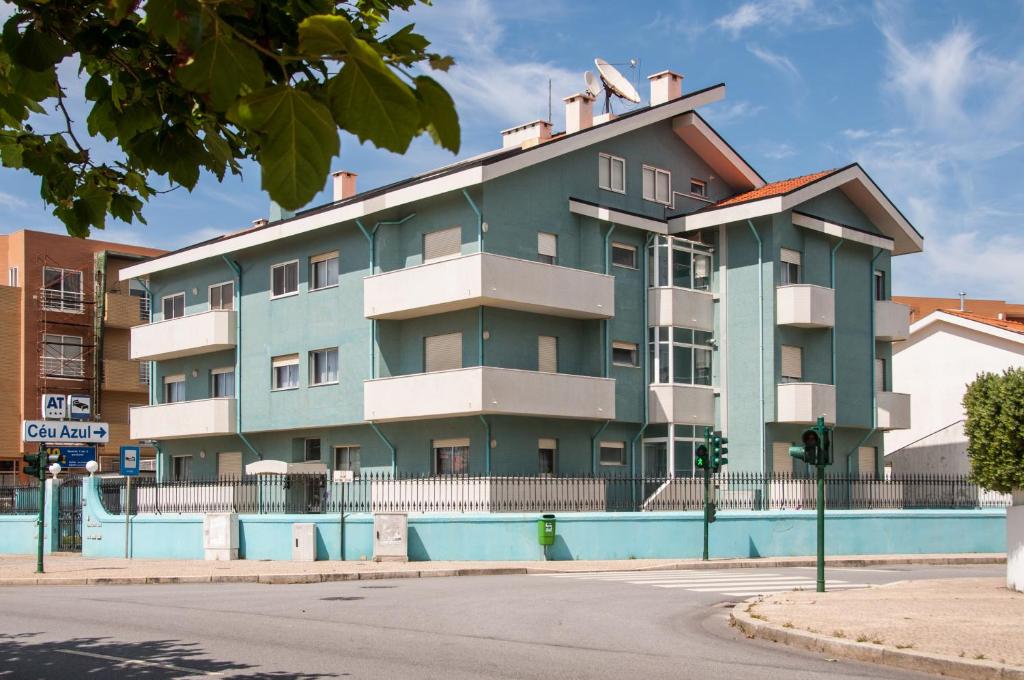 einem grünen Apartmentgebäude mit einem Pool davor in der Unterkunft Apartamentos Turisticos Ceu Azul in Arcozelo