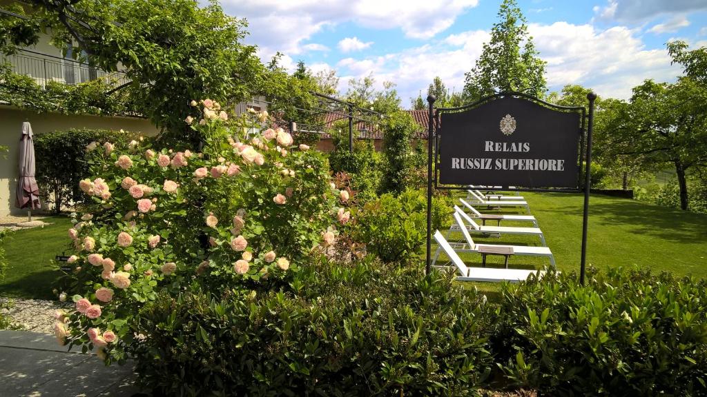 a sign for a hotel with a bunch of pink roses at Relais Russiz Superiore in Capriva del Friuli