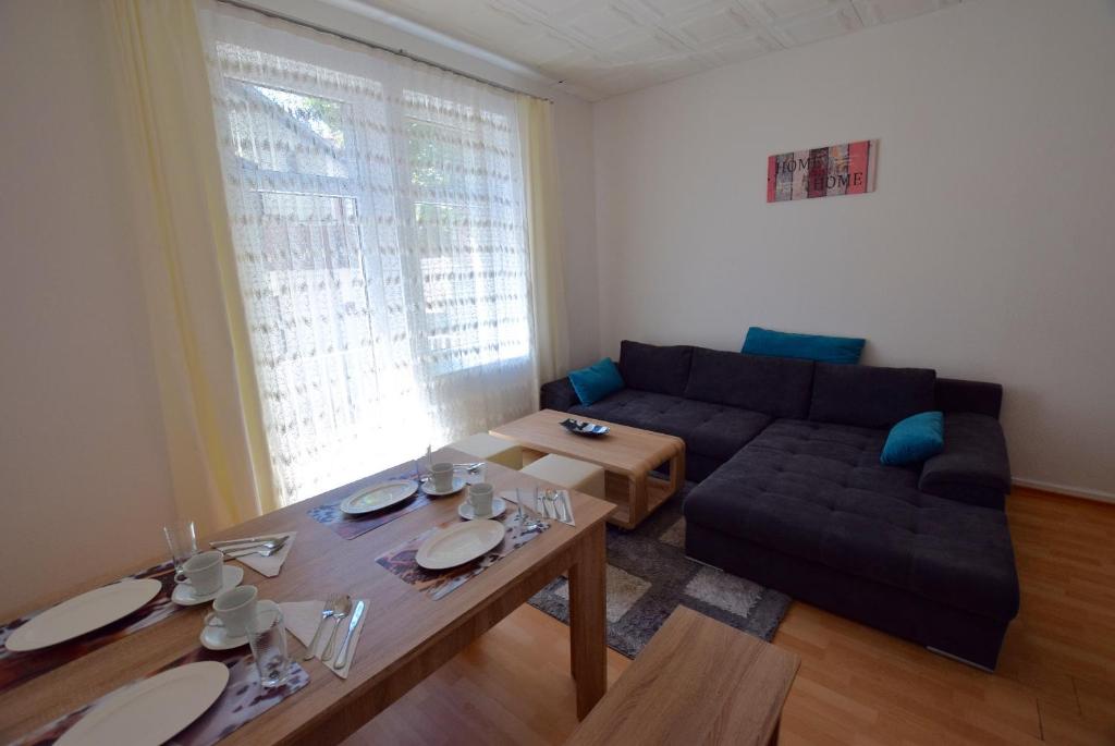 ein Wohnzimmer mit einem Sofa und einem Tisch in der Unterkunft Apartment Ostendplatz in Stuttgart