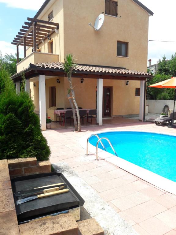 uma villa com piscina em frente a uma casa em Vacation Home Licinius em Ližnjan
