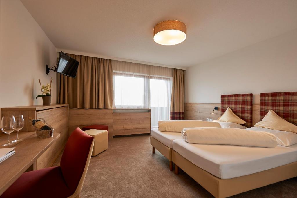 Postel nebo postele na pokoji v ubytování Alpenhotel Laurin