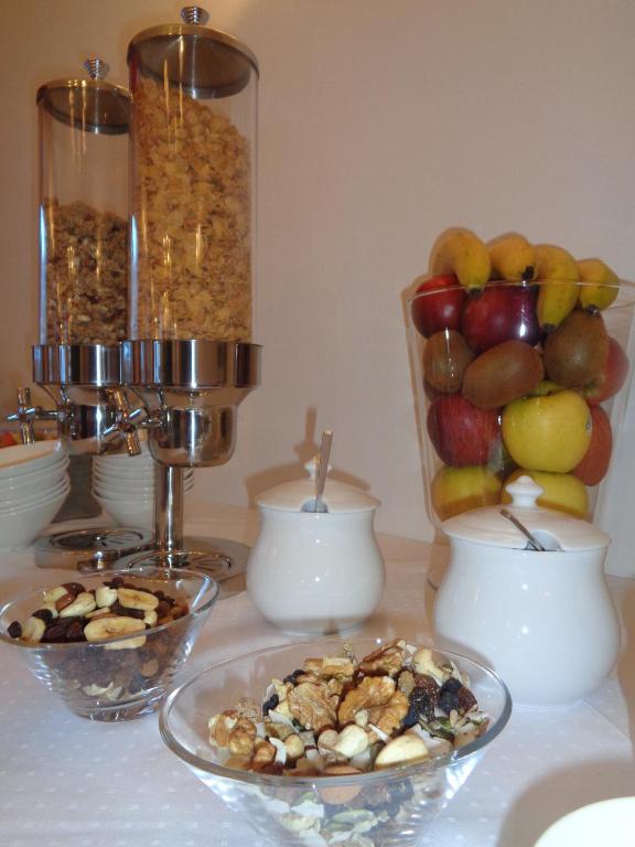a table topped with bowls of fruit and nuts at Hotel Garni Suisse in San Martino di Castrozza