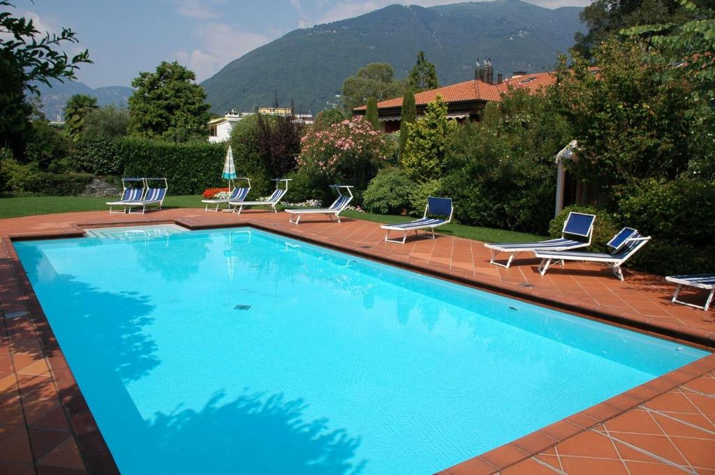 a large swimming pool with lounge chairs at Residenza Giardino - Chez Antoinette in Ascona