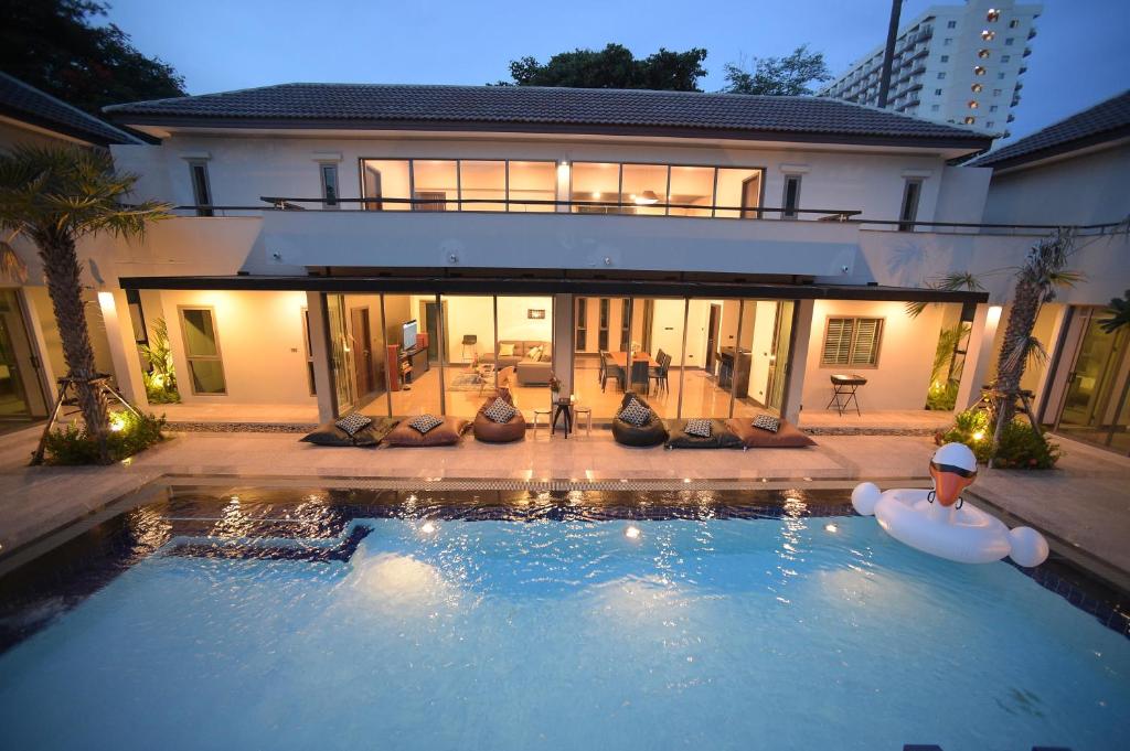 a large swimming pool in front of a house at Villa Navin Premiere Pool Villa in Jomtien Beach