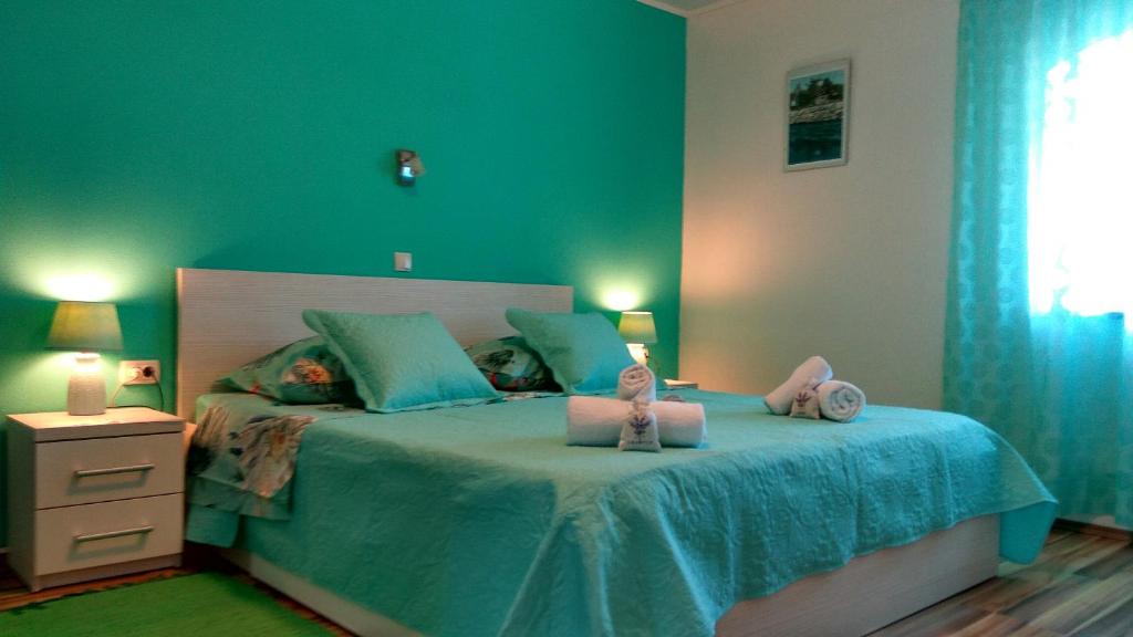 a bedroom with a bed with two stuffed animals on it at Apartments Jasminka in Solin
