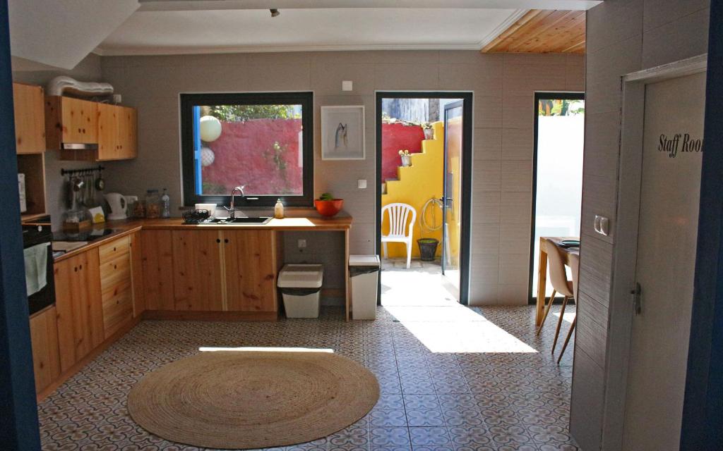 a kitchen with a sink and a counter with a table at Porto Pim Guest House in Horta