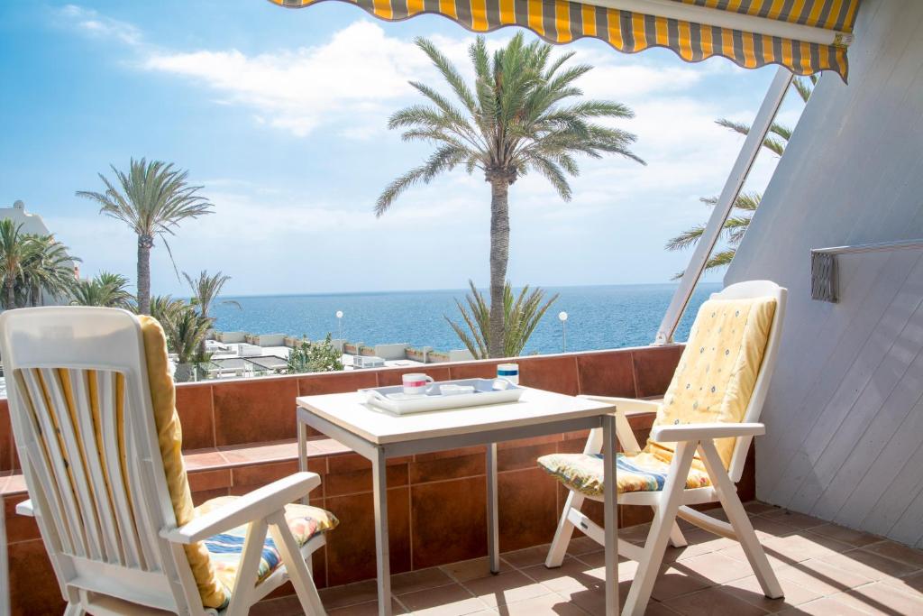 stół i krzesła na balkonie z widokiem na ocean w obiekcie AMAZING SEASIGHTS - TENERIFE w mieście Costa Del Silencio
