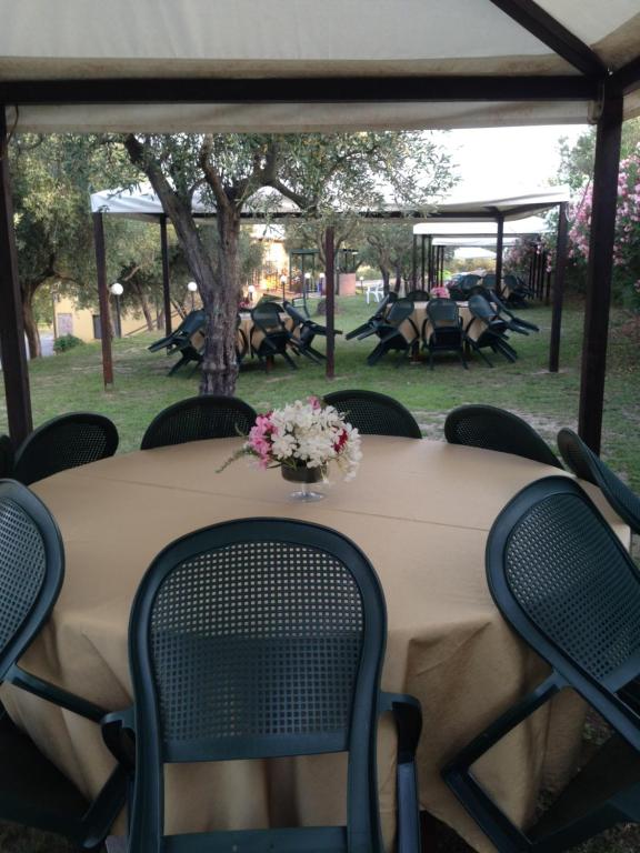 una mesa con sillas y un jarrón de flores. en Agriturismo Il Giriatello, en Crotone