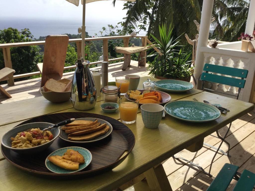 una mesa de madera con platos de comida. en Fantastic views at Friends, en Port Antonio