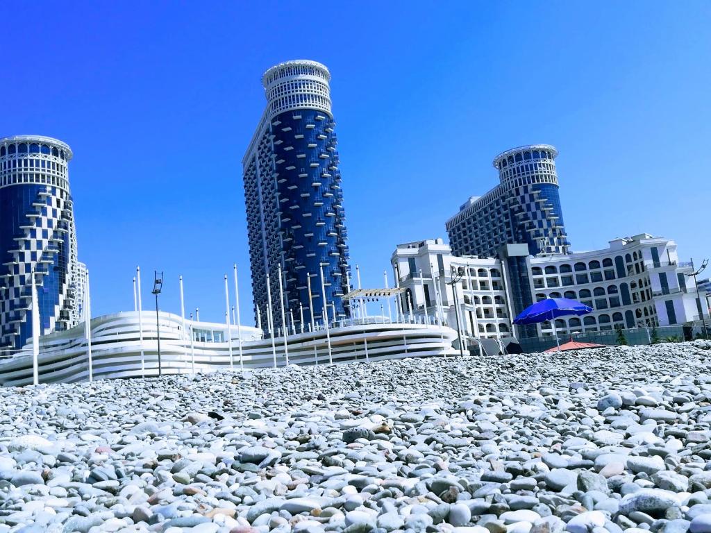una gran pila de rocas delante de los edificios en ORBI Towers Apartments Batumi, en Batumi