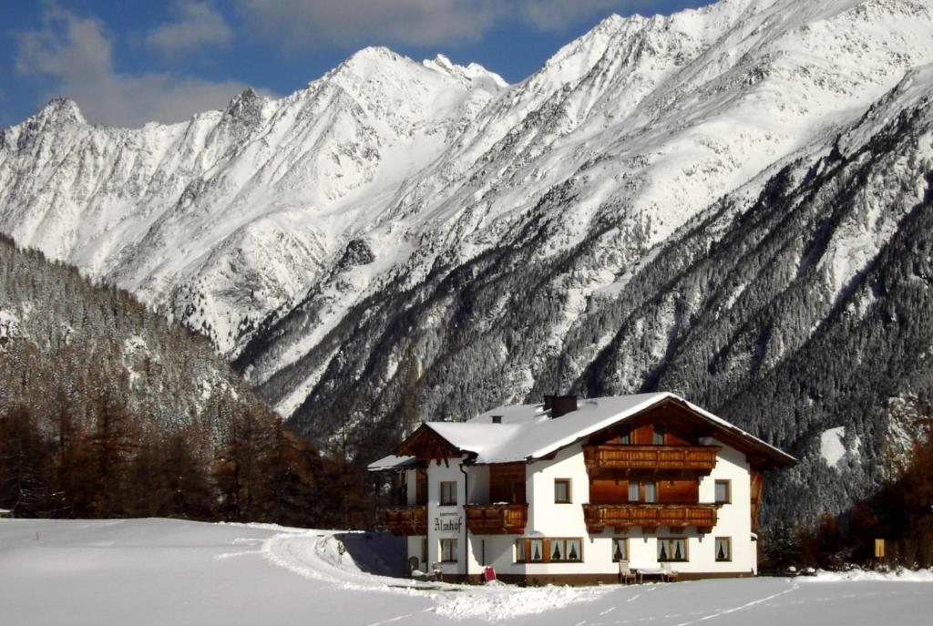 una cabaña en la nieve con montañas en el fondo en Almhof, en Sölden