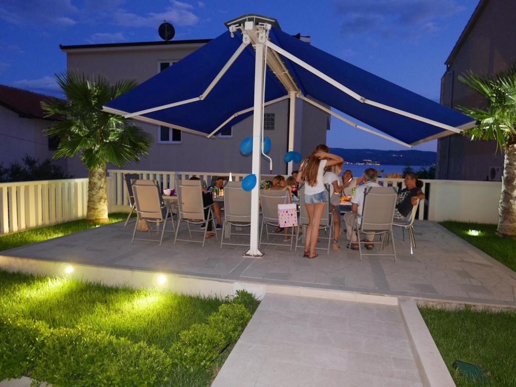a woman standing under a blue tent in a backyard at Two Palms in Duće