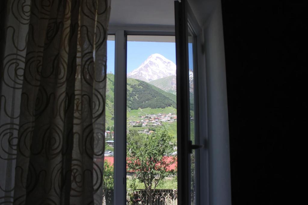 an open window with a view of a mountain at Inga Guest House in Stepantsminda