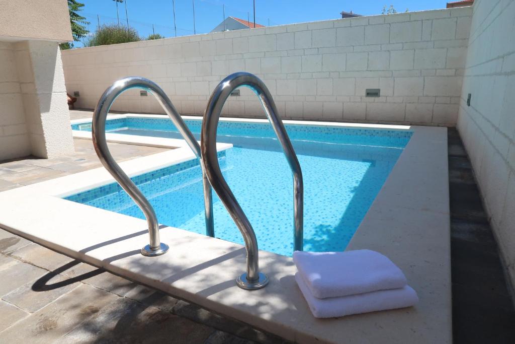 a swimming pool with a metal handrail next to a swimming pool at Villa Sunshine in Trogir