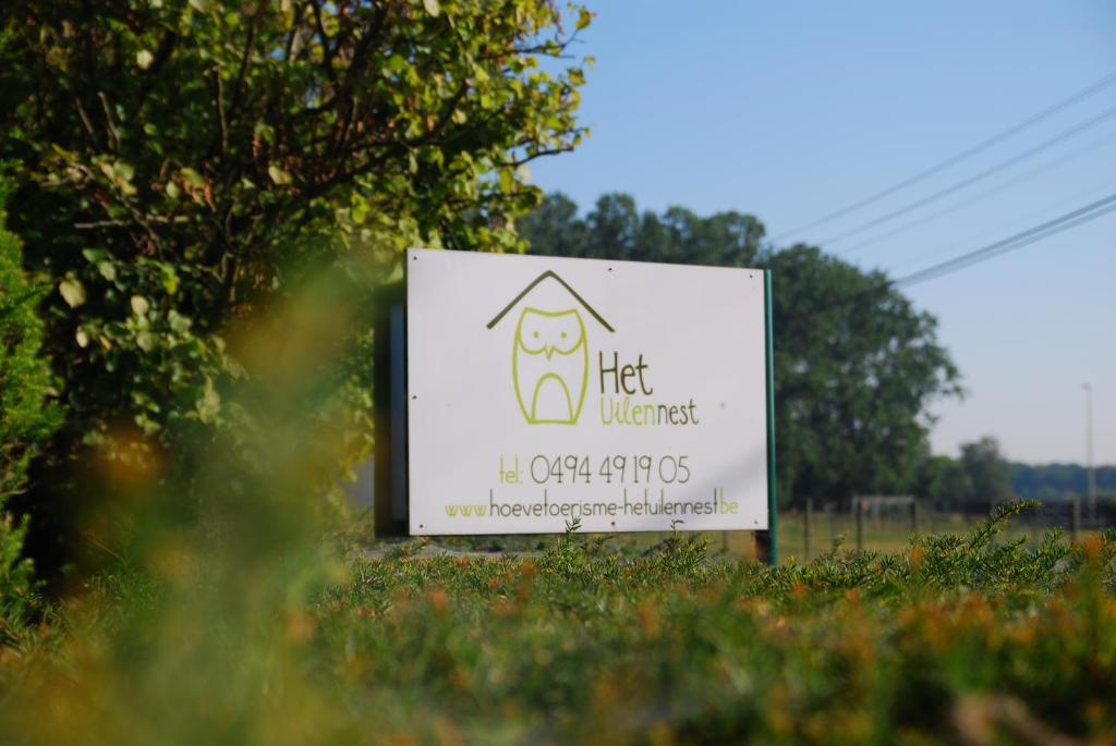 a sign in the grass in a field at B&B Het Uilennest in Bocholt