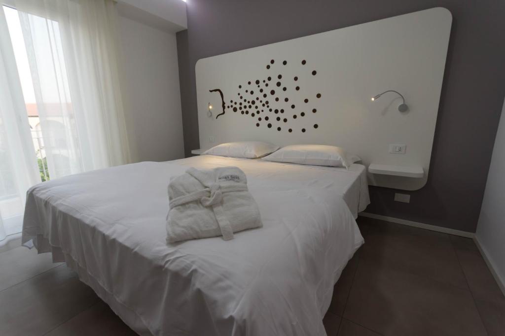 ein Schlafzimmer mit einem weißen Bett und Handtüchern darauf in der Unterkunft Aether Suites Tropea - Free Parking in Tropea