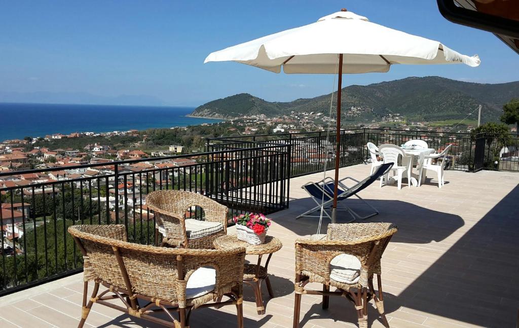 a patio with a table and chairs and an umbrella at Residence Domus Cilento in Castellabate