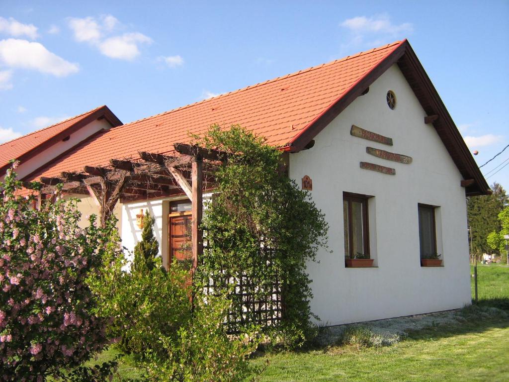 ein kleines weißes Haus mit orangefarbenem Dach in der Unterkunft Patakparti Apartman in Bozsok