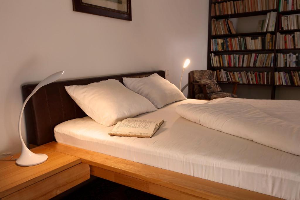 a bed with a lamp and a book on it at Villa Z - apartment with private parking in Brno