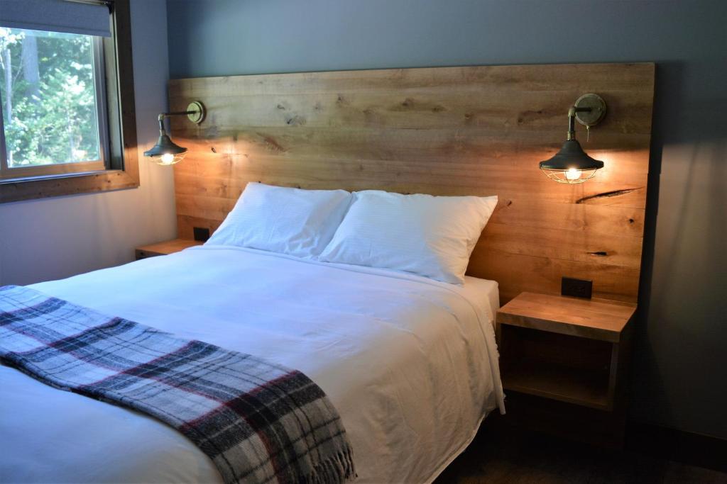 una camera da letto con un grande letto bianco con due luci di Sasquatch Inn a Harrison Mills