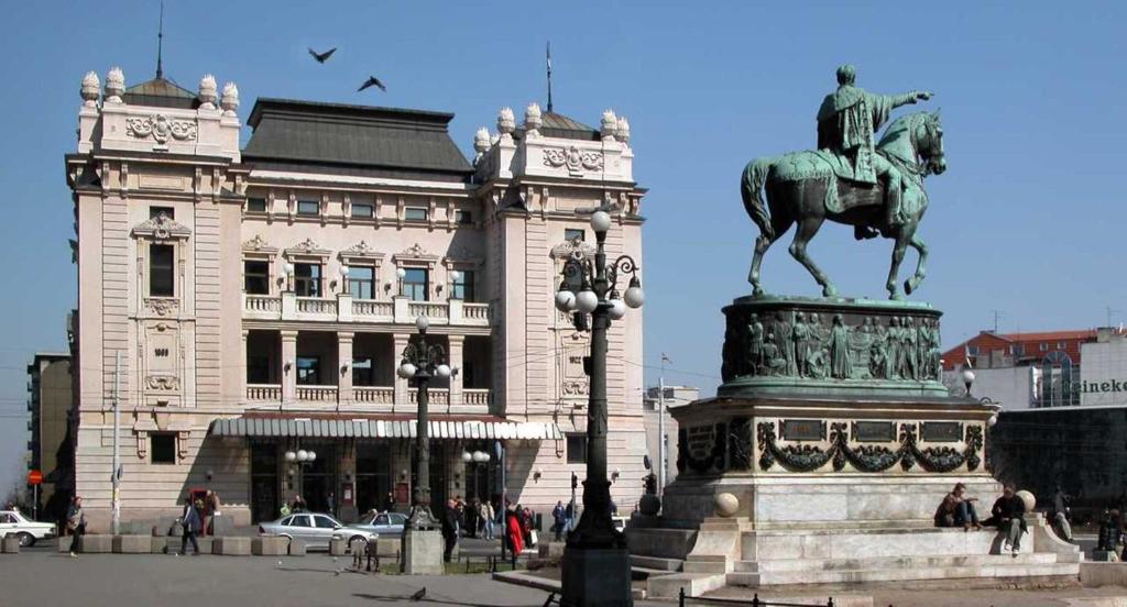 a statue of a man on a horse in front of a building at Manjež Centar in Belgrade