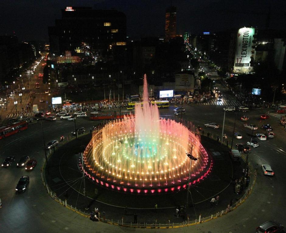 a fountain in the middle of a city at night at Manjež Centar in Belgrade