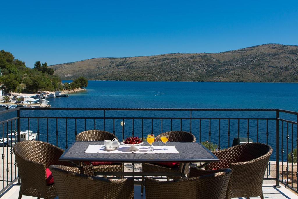 una mesa en un balcón con vistas al lago en Apartments Iris, en Marina