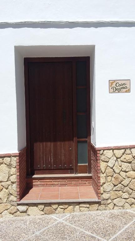 eine Holztür auf einem Gebäude mit einer Steinmauer in der Unterkunft Dayma in Medina-Sidonia