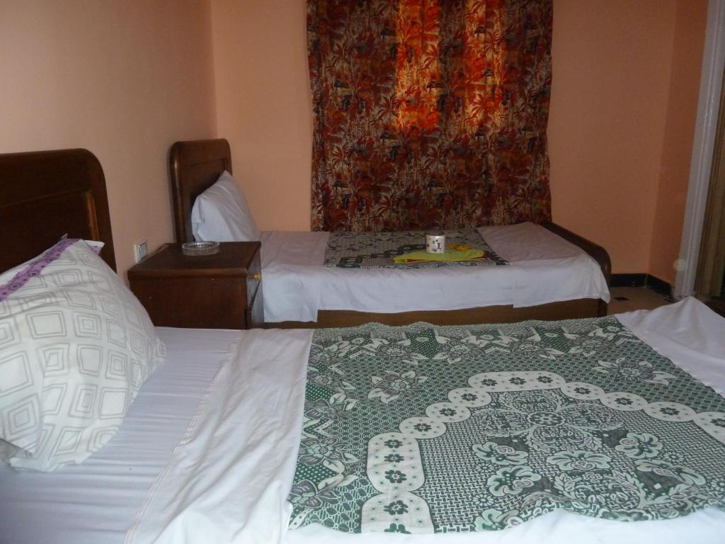a hotel room with two beds and a curtain at Venus Hostel in Cairo