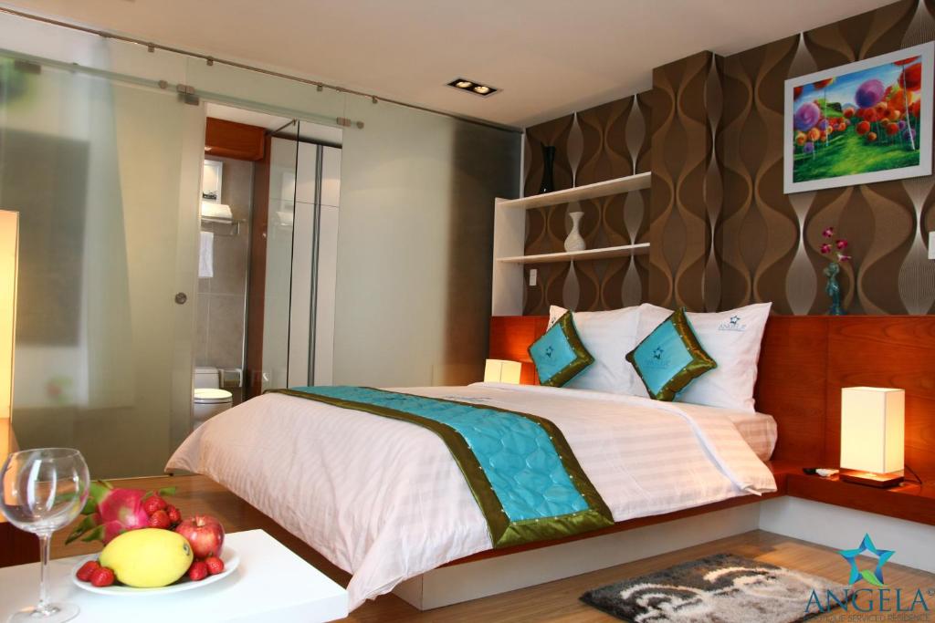 1 dormitorio con 1 cama y un plato de fruta en una mesa en Angela Boutique Serviced Residence, en Ho Chi Minh