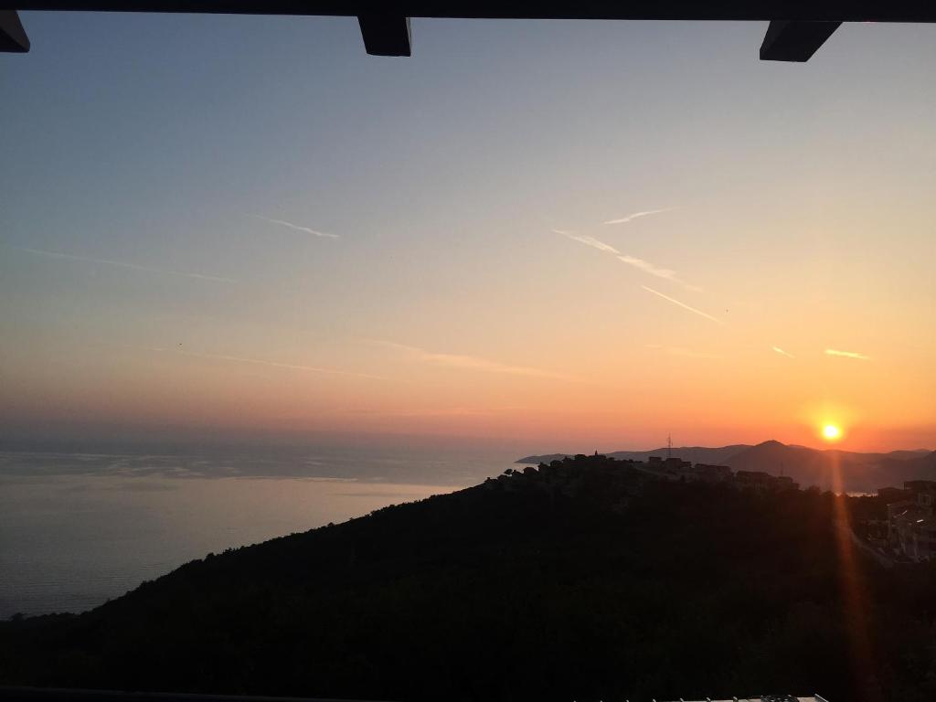 a view of the sun setting over the ocean at Perla Residence Apartment in Sveti Stefan