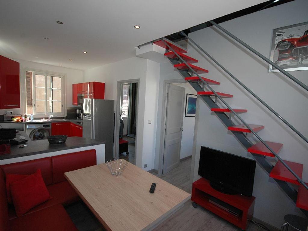 a staircase in a kitchen with a living room at Maison Vauban Plus in Saint-Raphaël