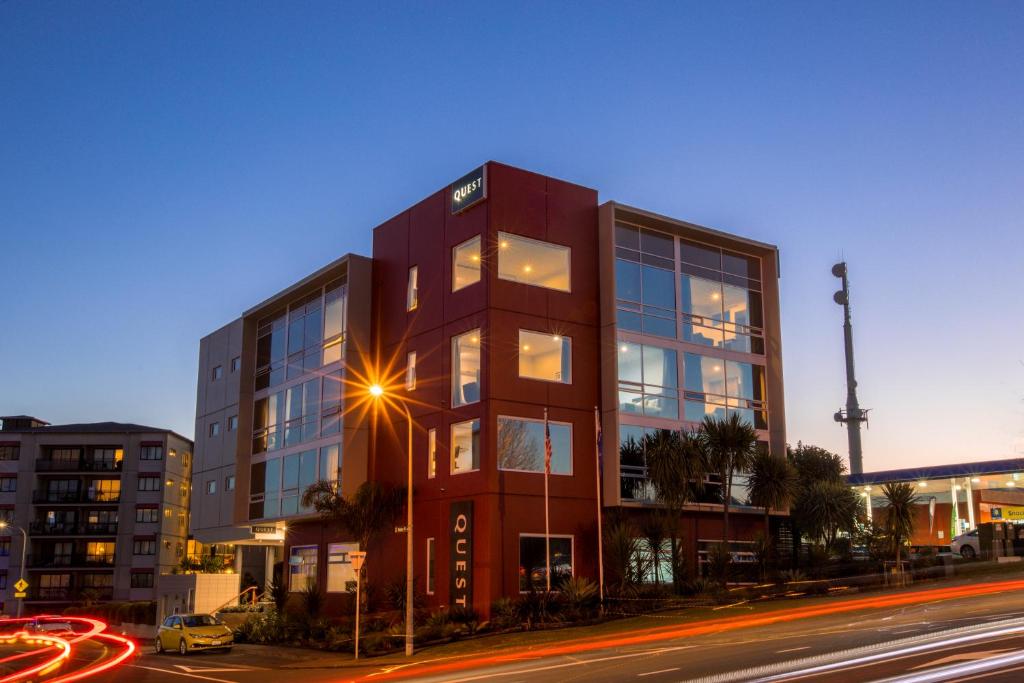 a tall red building on a city street at night at Quest Henderson Serviced Apartments in Auckland