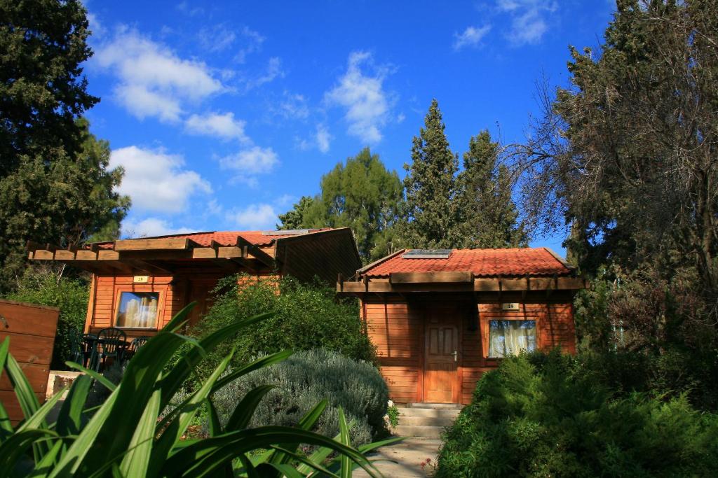 a wooden house with a red roof at Zohar Badeshe in Daliyya