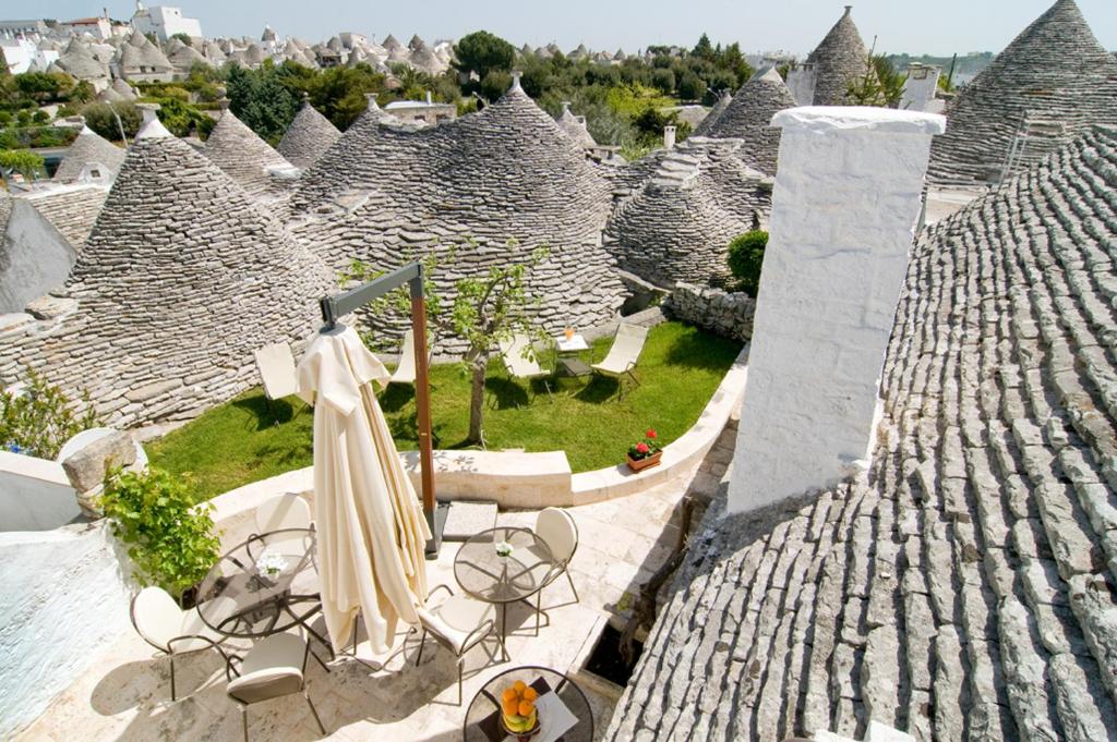 a group of roofs with chairs and umbrellas on a roof at Tipico Suite in Alberobello