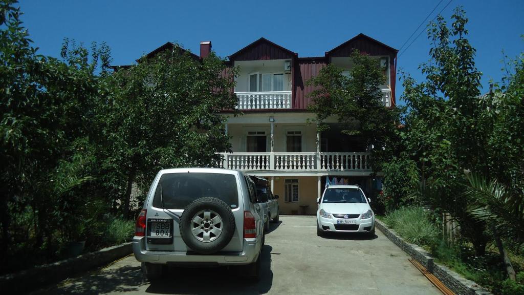 dos autos están estacionados frente a una casa en Gios Guest House, en Chakvi