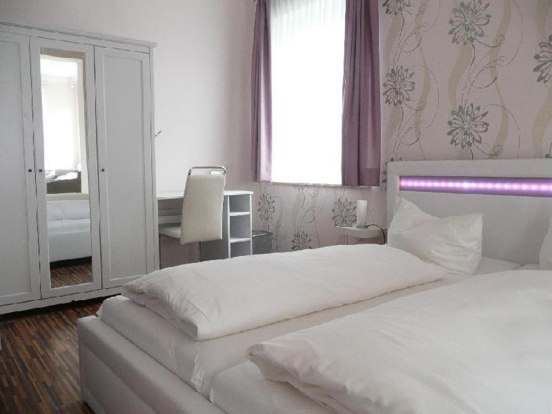 a bedroom with a white bed and a mirror at H5 Hotel Bremen in Bremen