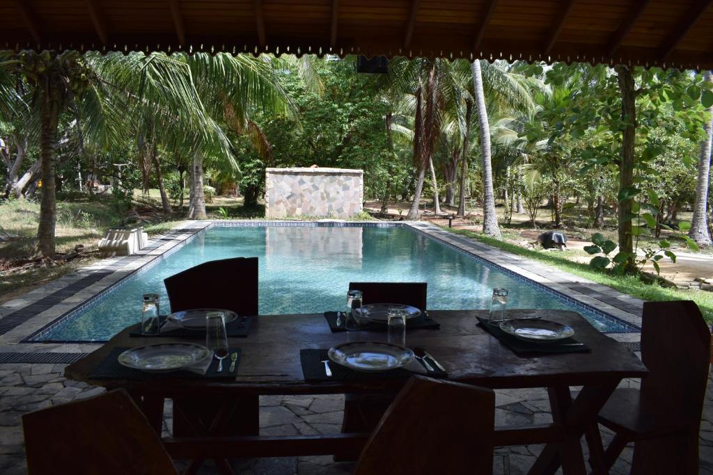a table and chairs in front of a swimming pool at Marian Holiday Bungalow in Puttalam