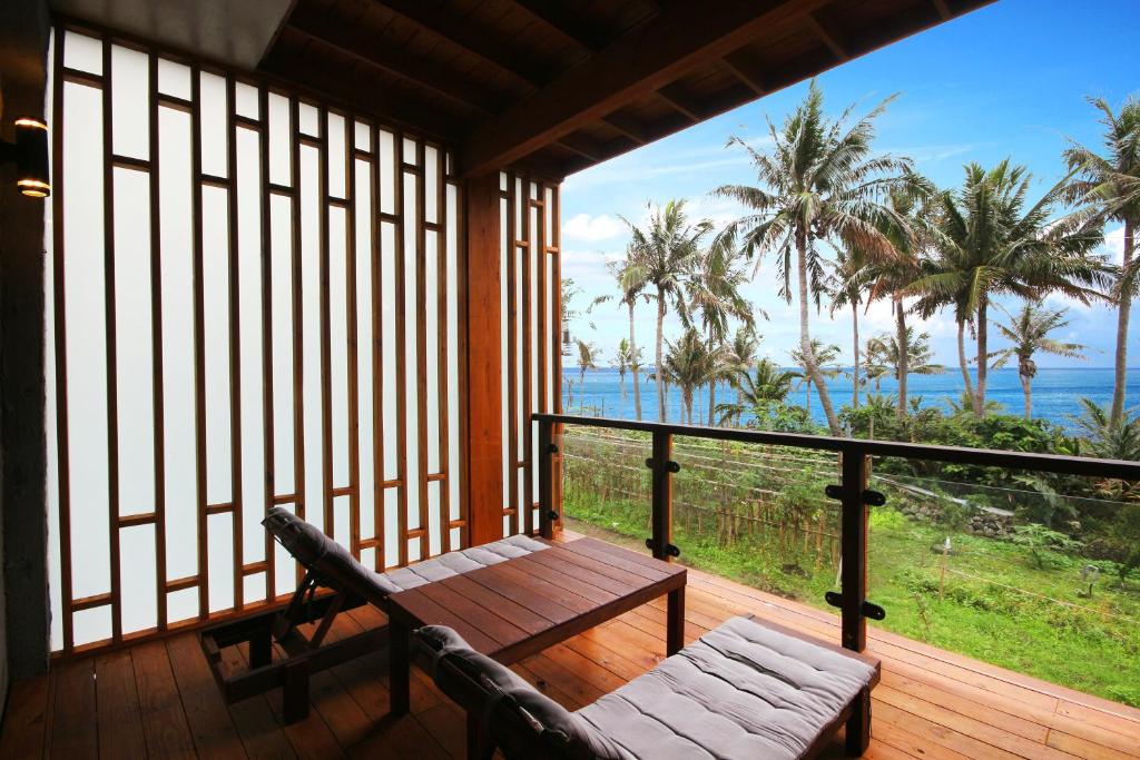 - une terrasse couverte avec un banc et une vue sur l'océan dans l'établissement 海景擁月星宿民宿, à Chenggong