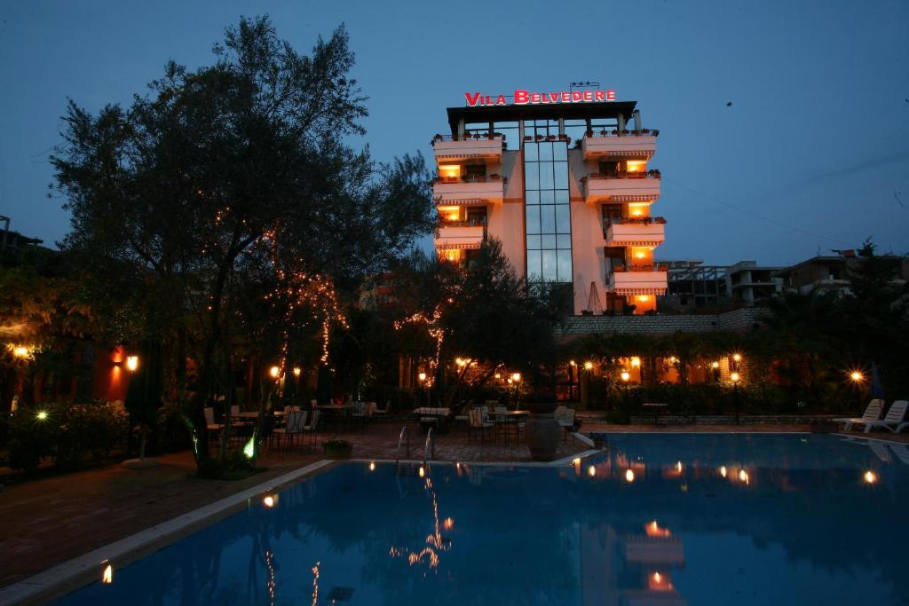 a hotel with a swimming pool in front of a building at Vila Belvedere in Durrës