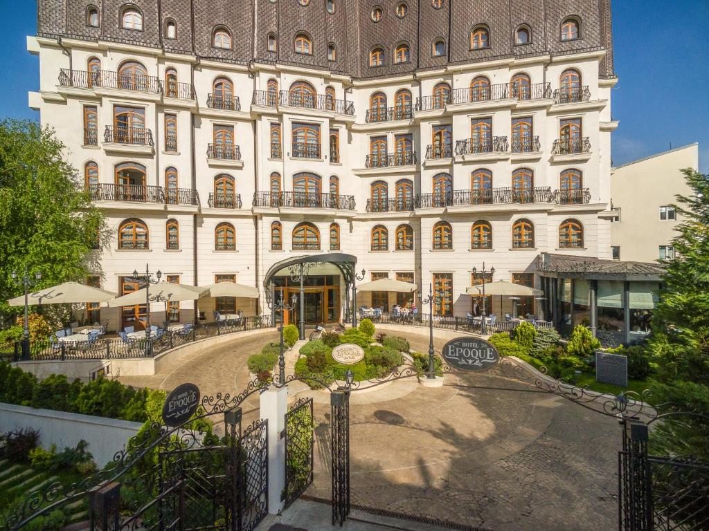 um grande edifício com um jardim em frente em Epoque Hotel - Relais & Chateaux em Bucareste