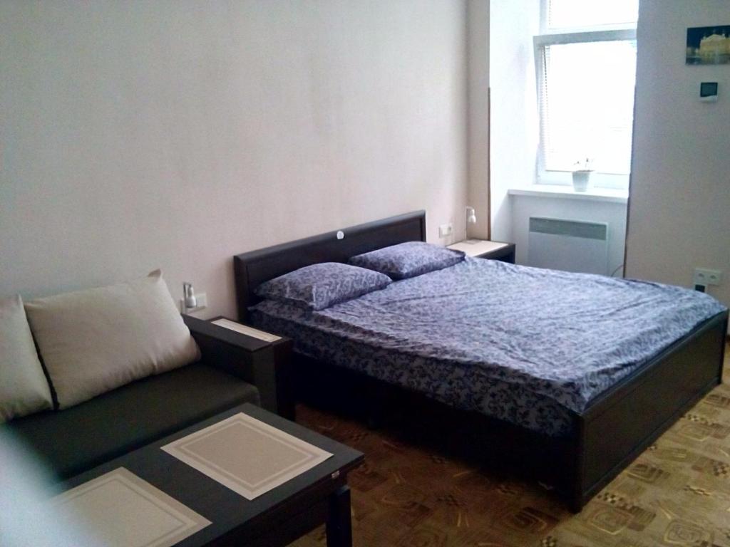 リヴィウにあるSkovoroda apartmentの小さなベッドルーム(ベッド1台、ソファ付)
